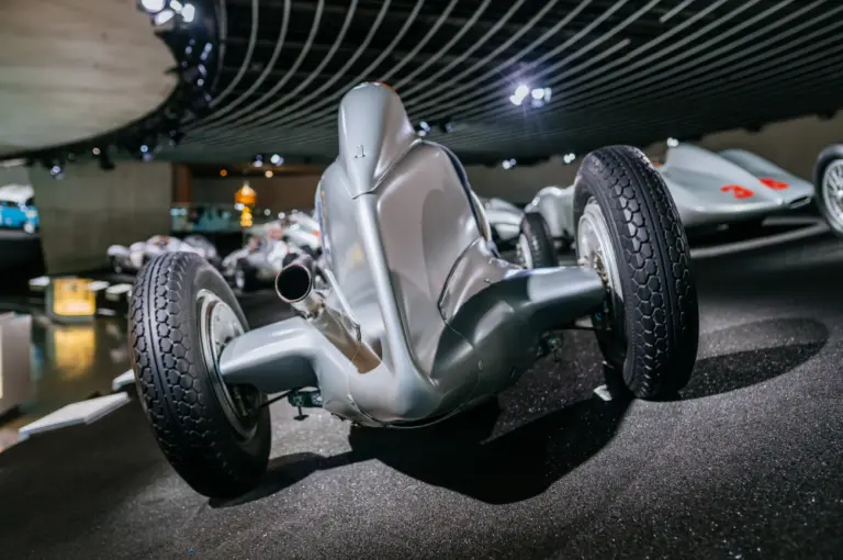 Mercedes-Benz Museum, Raum Mythos 7: Silberpfeile – Rennen und Rekorde. Mercedes-Benz 750-Kilogramm-Formelrennwagen W 25. Ansicht von hinten mit dem spitz zulaufenden Stromlinienheck. Rechts im Hintergrund der W 25 Stromlinienrennwagen „Avus“ aus dem Jahr 1937 aus erhöhter Position. (Fotosignatur der Mercedes-Benz Classic Archive: D830835) Mercedes-Benz Museum, Legend Room 7: Silver Arrows – Races and Records. Mercedes-Benz 750-kilogram W 25 formula racing car. Rear view of the tapered ,streamlined rear end. On the right in the background, the W 25 streamlined “Avus” racing car of 1937 from an elevated position. (Photo index number in the Mercedes-Benz Classic Archives: D830835) D830835
