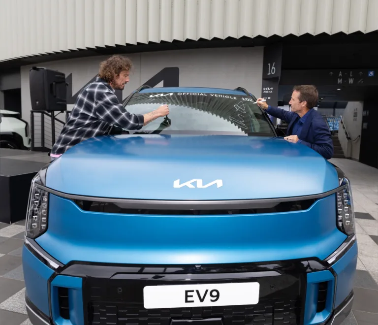 대회공식차량 중 EV9에 사인하고 있는 러시아 테니스 레전드 마라트 사핀(Marat Safin)과 호주 경마 레전드이자 기아 호주법인 앰버서더 데이미언 올리버(Damien Oliver)